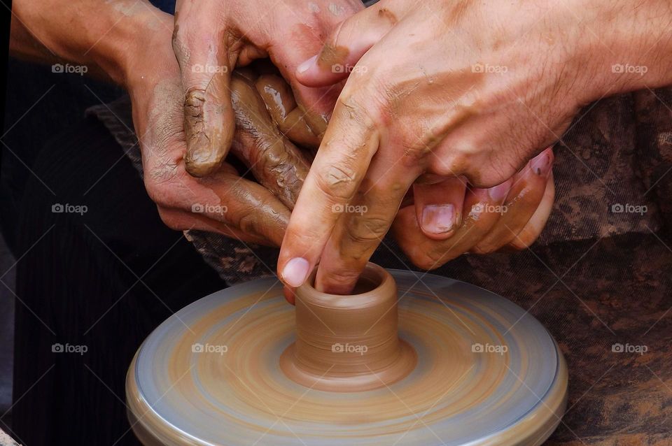 man makes pottery out of clay