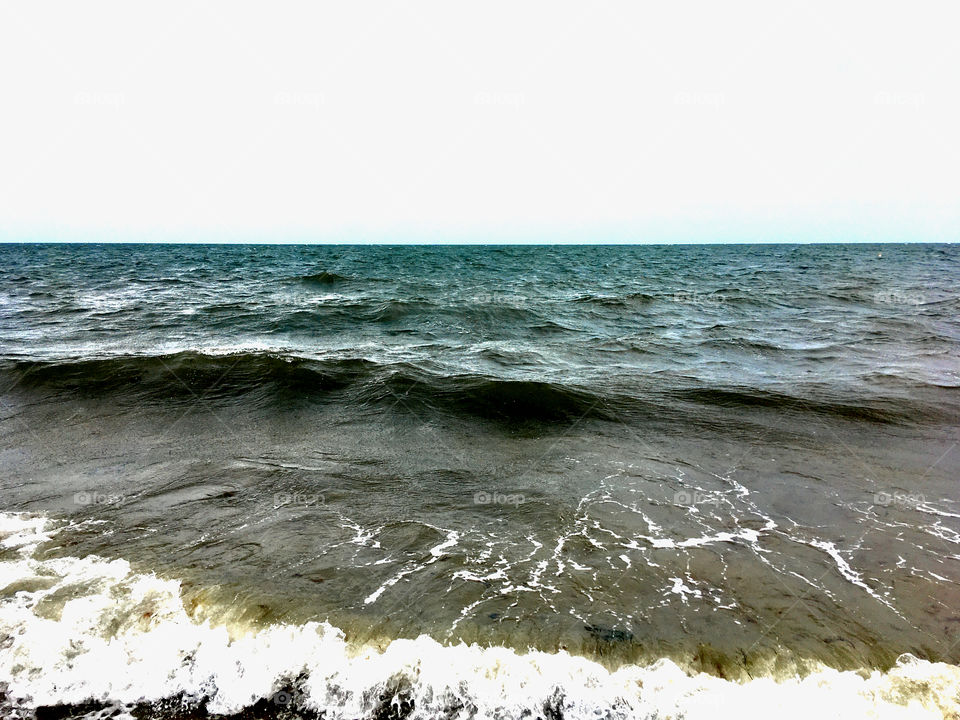 Gentle Nantucket Sound surf and sea foam at Parkers River Beach, South Yarmouth, Cape Cod.  Sharp horizon. 