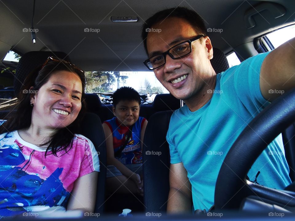 selfie or groupfie or wefie shot of a young couple with their young son inside a car
