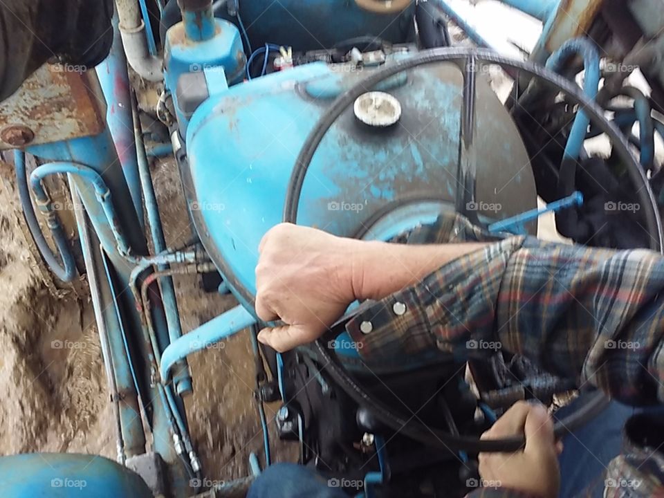 My Rancher, fording the flood on his 1950s Fordson Super Major tractor.  I love to look at his hands.