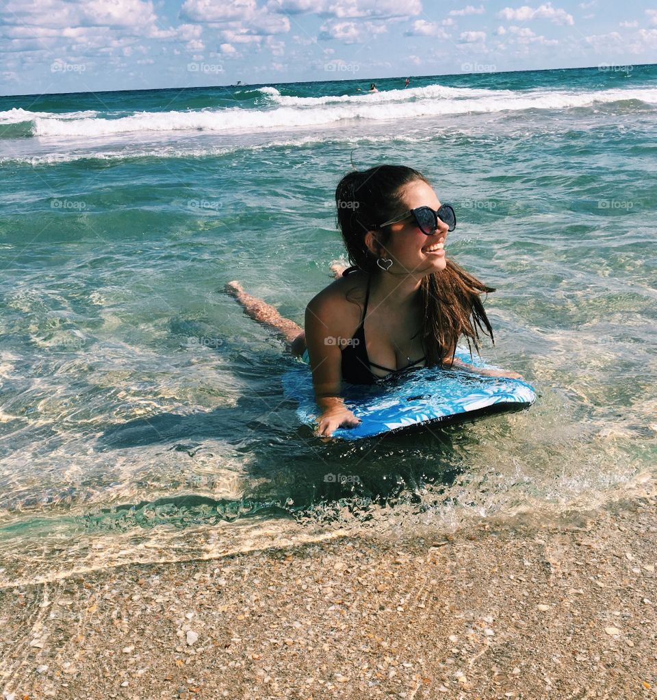 Woman lying on surf board