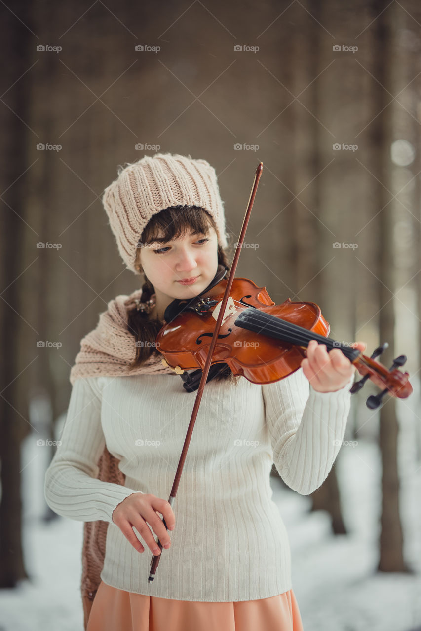 Teenage girl portrait with violin in winter park