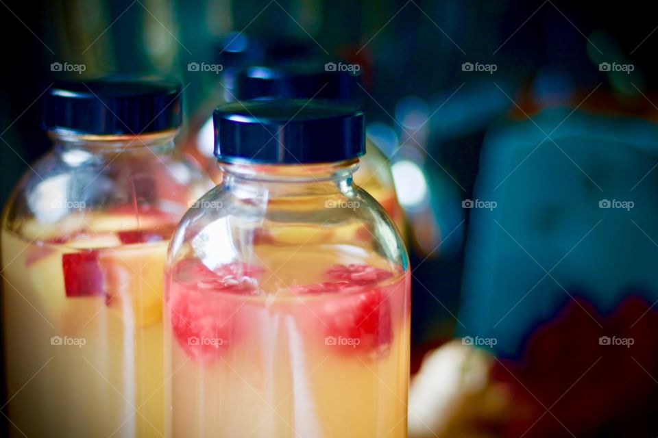 Closeup of kombucha, bottled for a second-ferment and flavored with nectarines and raspberries