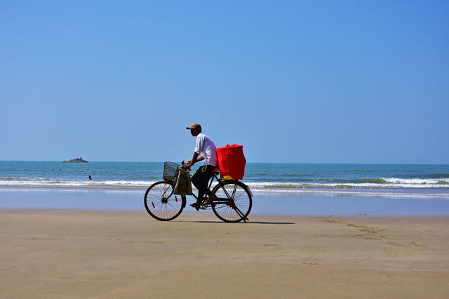 salesman on his bicycle in a beach