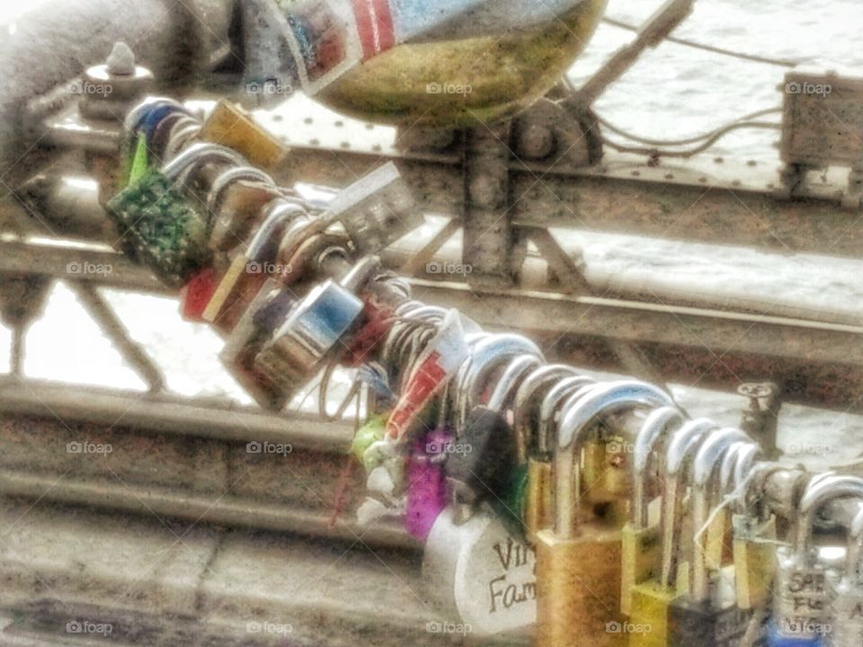 hdr image of metal love locks hanging in a cluster on the  Brooklyn bridge in new york