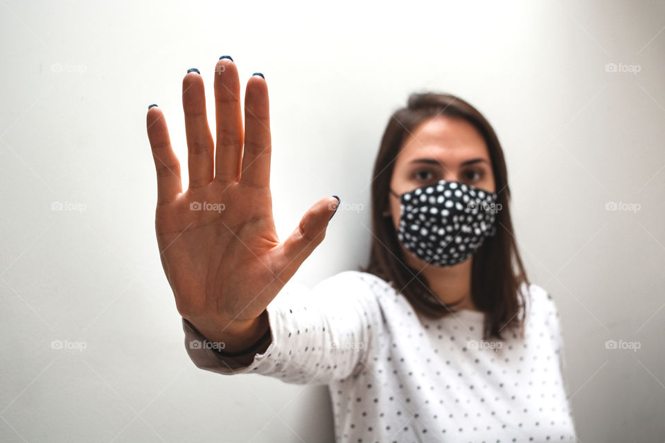 Woman wearing a face mask showing her hand