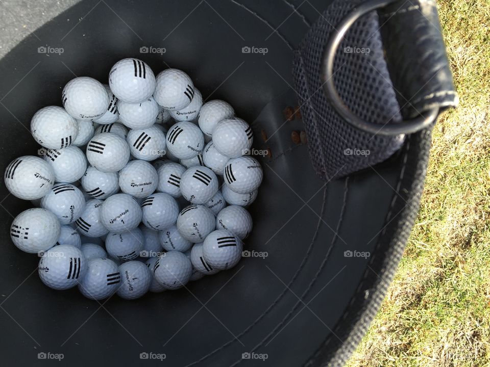 Golf . Practice golf balls in a container 