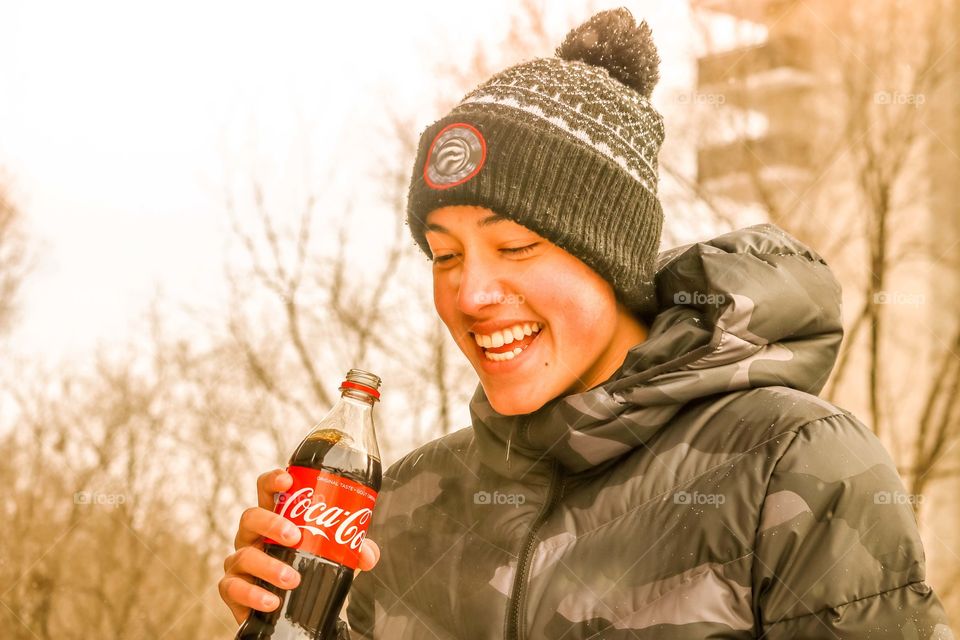 Happy teenager with a bottle of coca cola