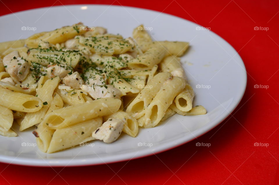 Pasta and chicken garnished on plate