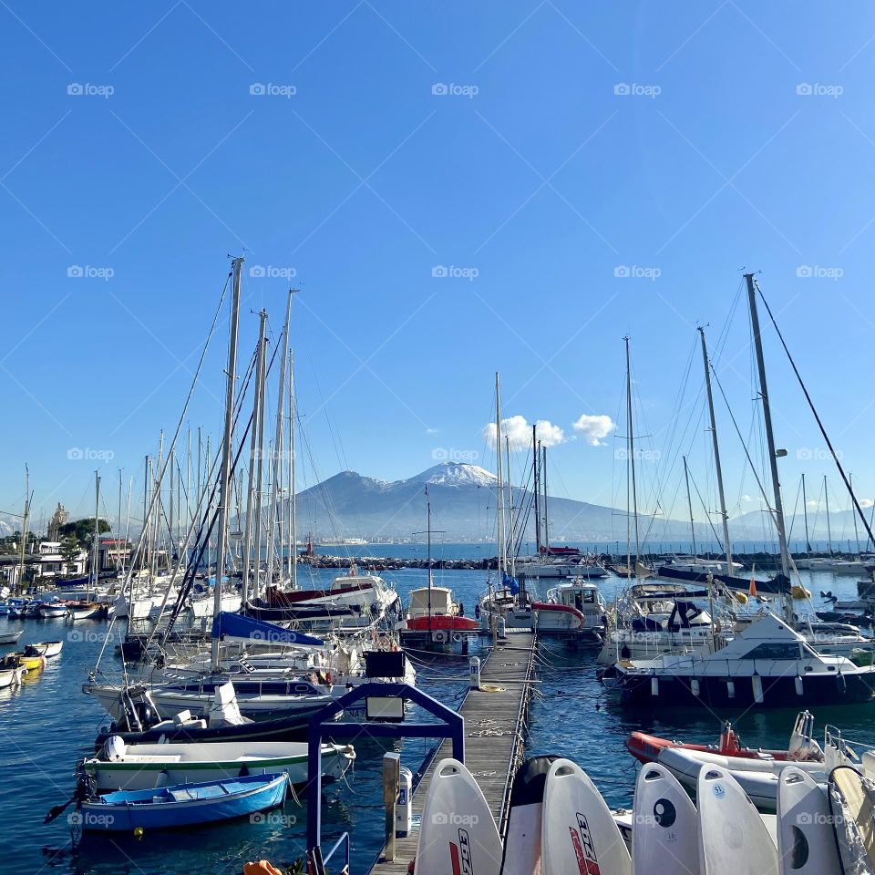 Bright marina with Mount Vesuvius in the background, capturing the beauty of Naples. A vibrant scene showcasing boats, clear skies, and the essence of this incredible city I love.