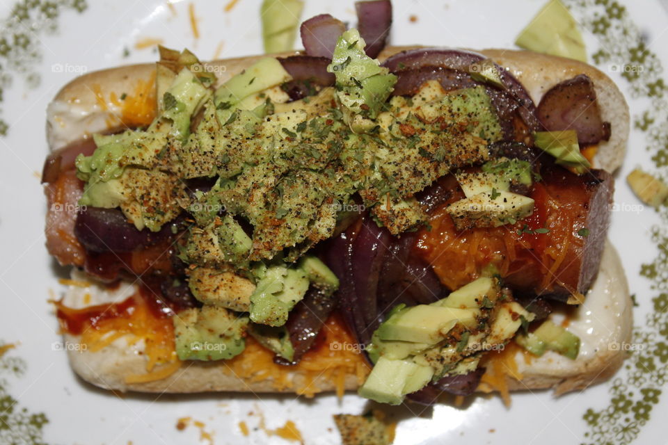 homemade kielbasa hot dog, caramelized red onions, sharp cheddar cheese, top with avocado
