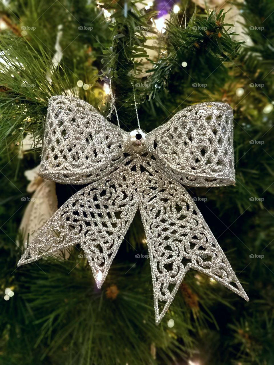 Silver bow ornament on a Christmas tree