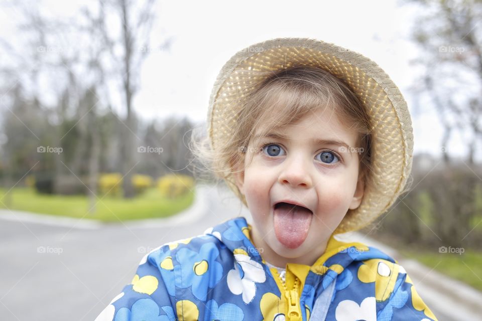 little girl make face tongue out