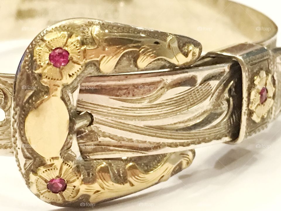 Close-up of a handcrafted bracelet designed to look like a belt buckle. 