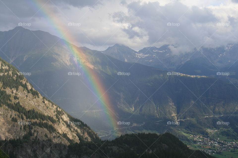Rainbow in the Alps. Beautiful rainbow above the Swiss town Brig captured from the Belalp.