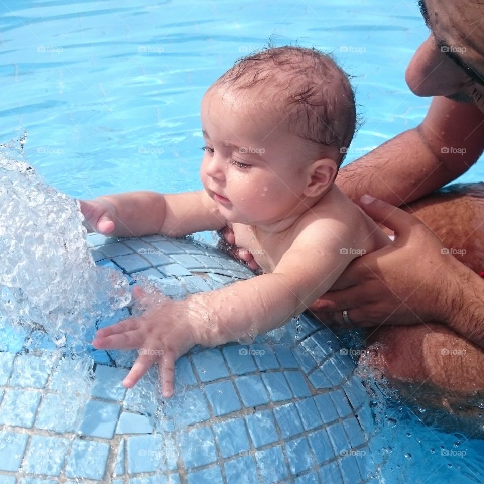 water fun. father and baby girl in swimming pool