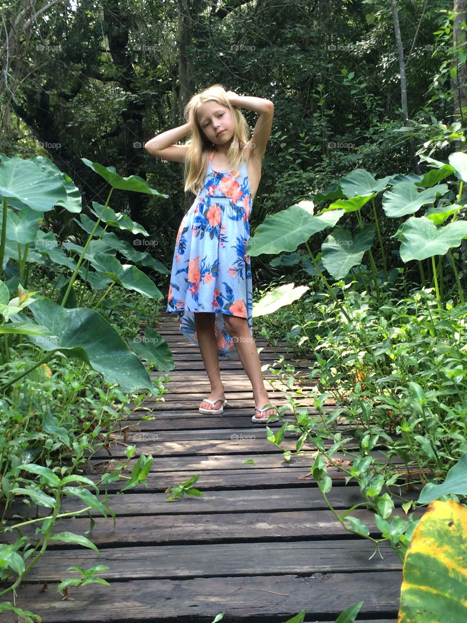 Little girl on a small bridge in the woods