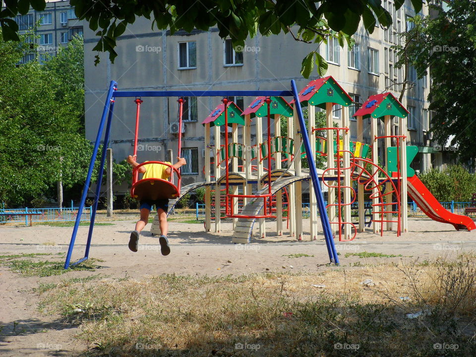 boy swinging on a swing at the playground