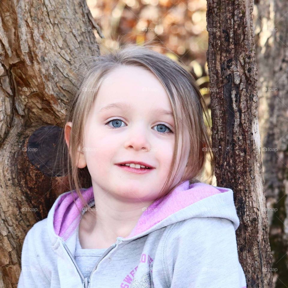 blue eyes in front of a tree