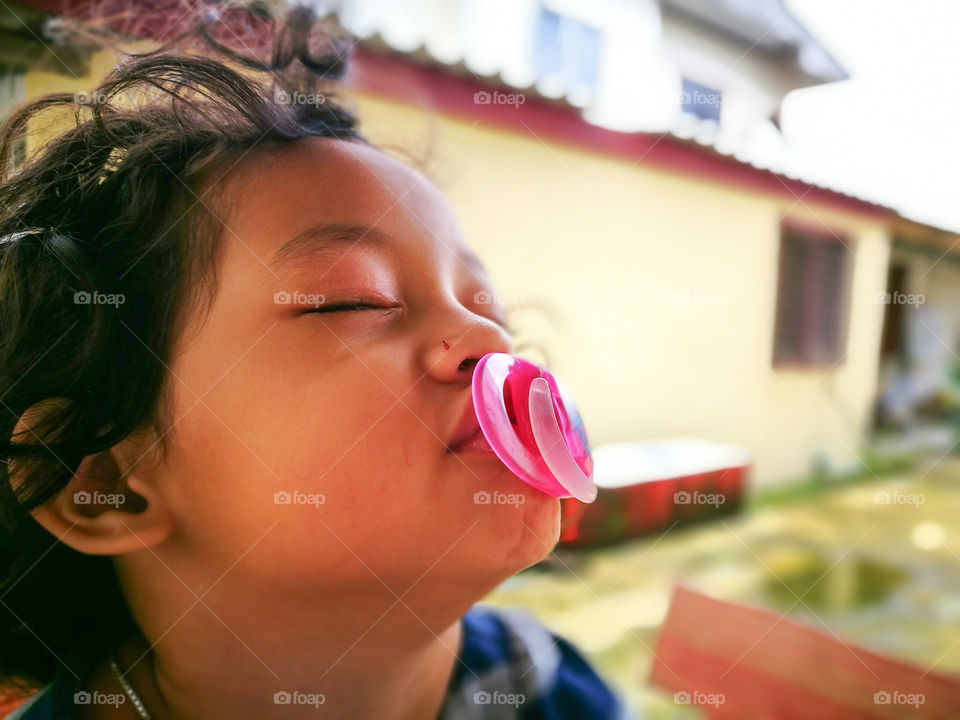 Cute girl with pacifier in his mouth