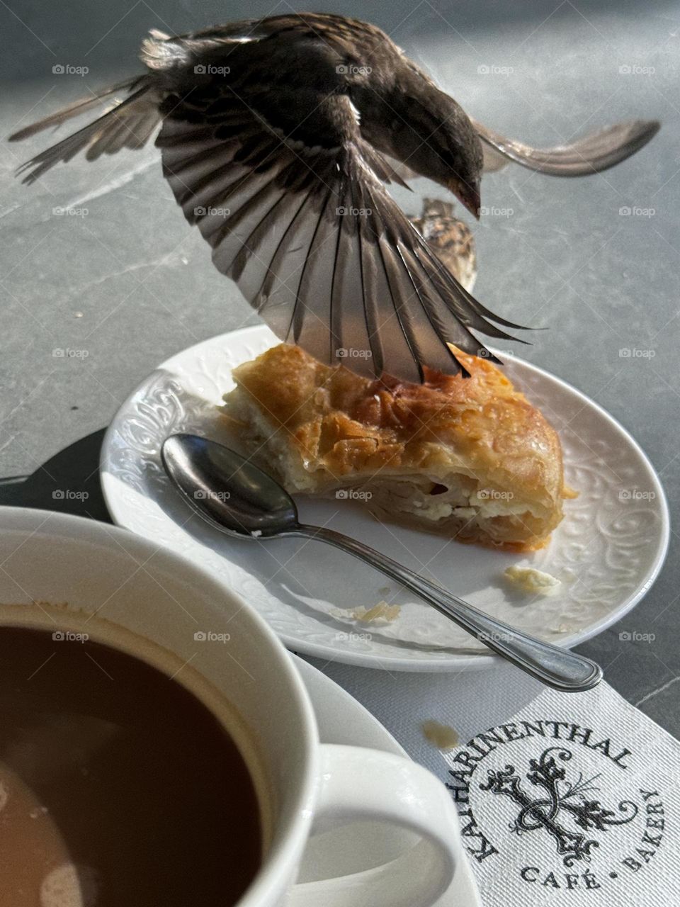 A sparrow flies over a pie in a plate