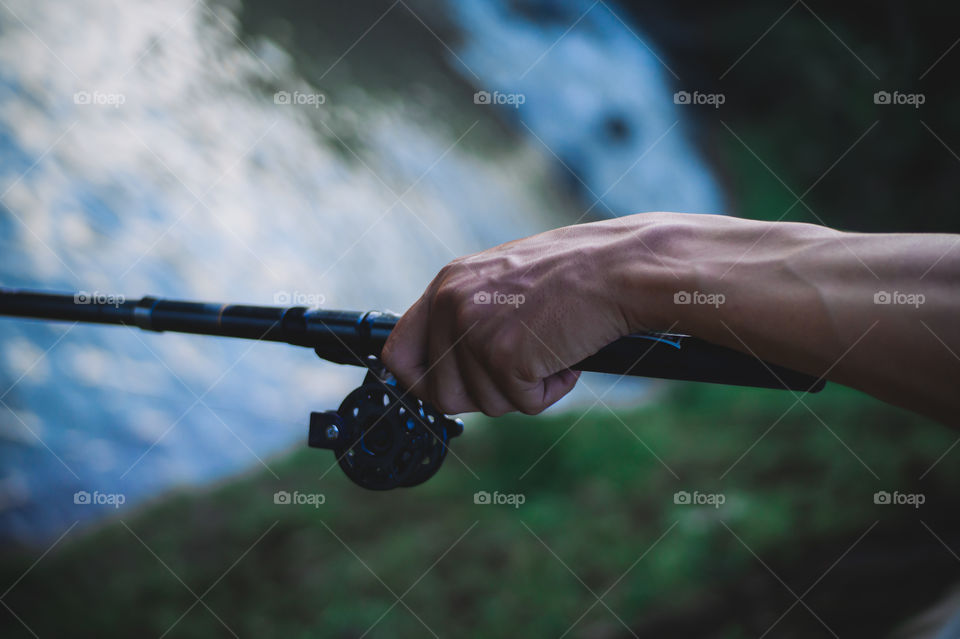 Close-up of a fisherman's hand pulling a fish hook