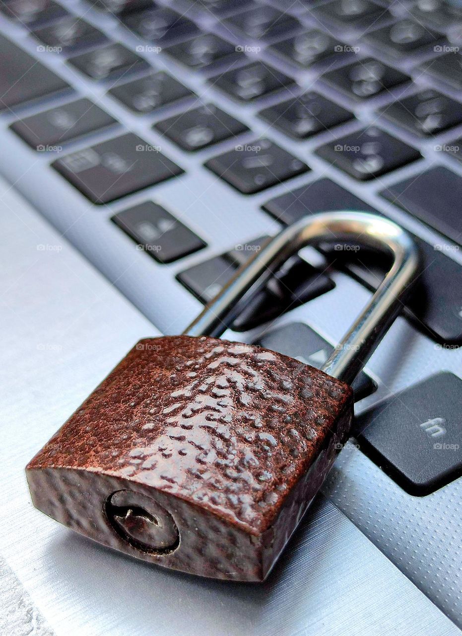 Metal.  On the corner of the laptop keyboard is a metal lock with a closed darling.  Photo metaphor about information security