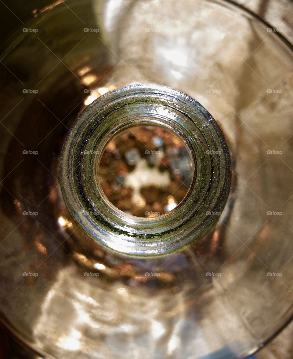 Overhead closeup of mouth of large glass jar holding spare change