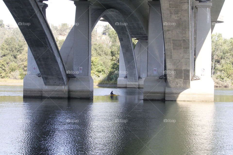 kayaking under a bridge
