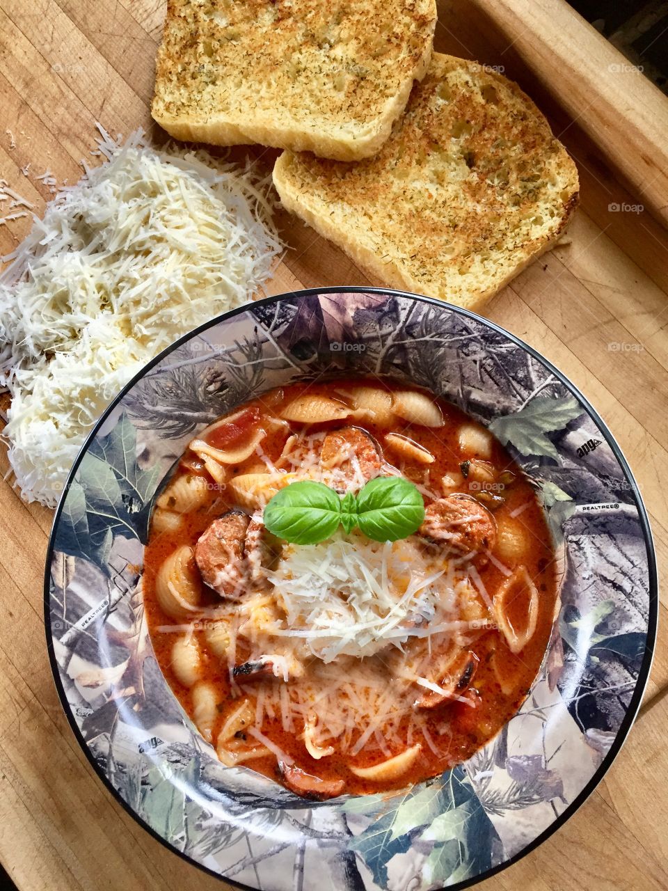 Homemade sausage and pasta shell soup sprinkled with asiago cheese and served with homemade garlic toast. Lunch is served. 