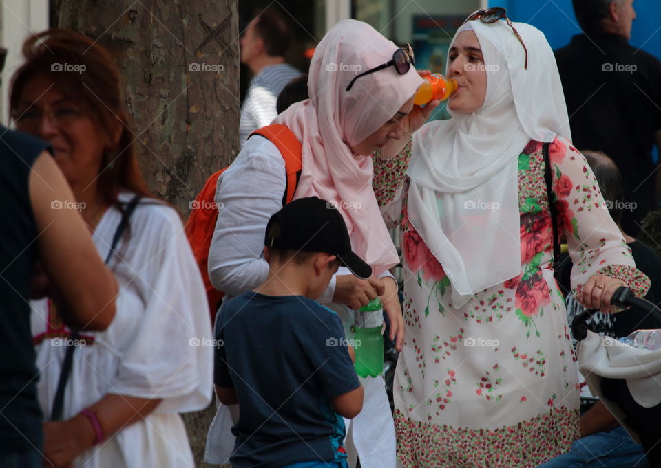 Street Photography.Muslim Woman Enjoying A Fanta Soft Drink In Public