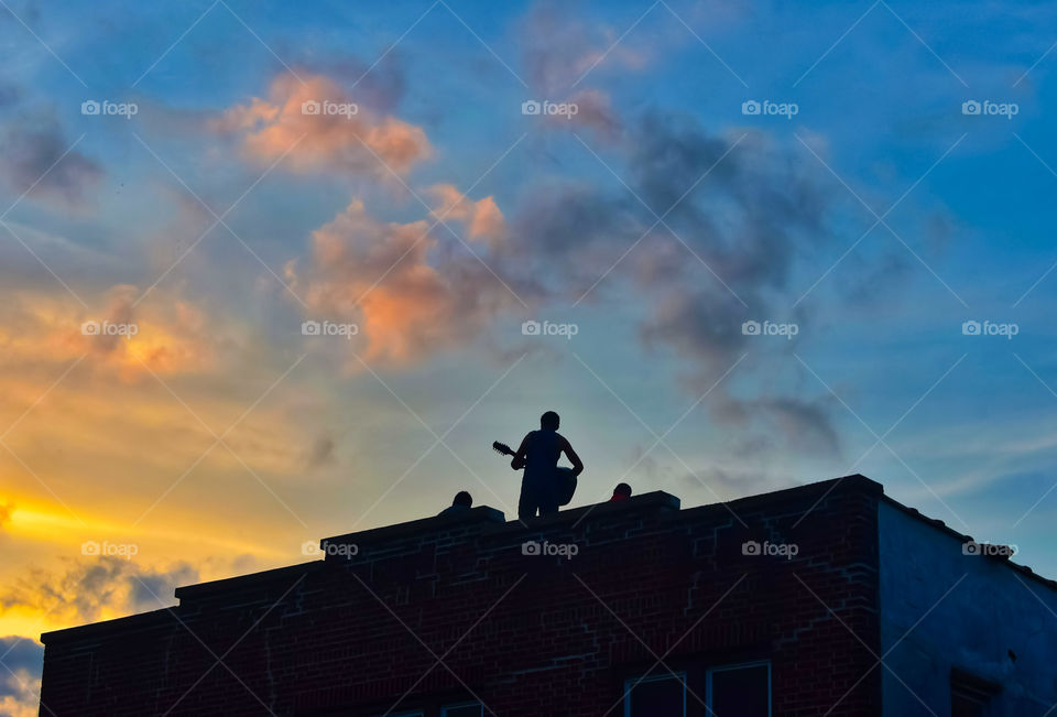 Playing Guitar On A Roof In The Sunset