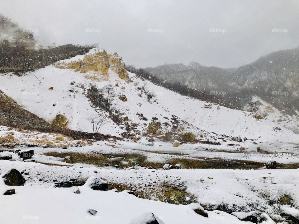 Jigokudani or Hell Valley wooden walkway bridge in the town of Noboribetsu Onsen, hot steam vents, sulfurous streams and other volcanic activity, hot spring waters, Hokkaido, Japan, winter with snow