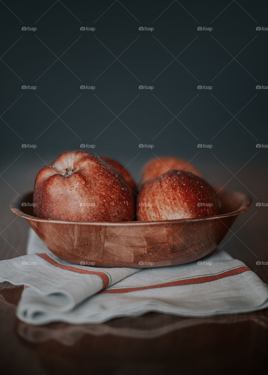 Close-up of apples in wooden bowl on tabel.