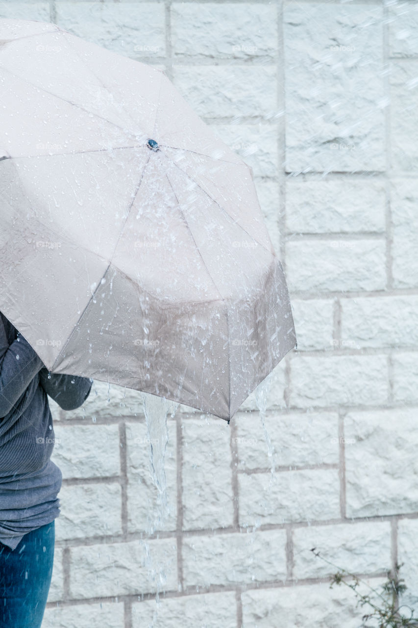 Woman with umbrella. Woman using umbrella to protect herself from rain 