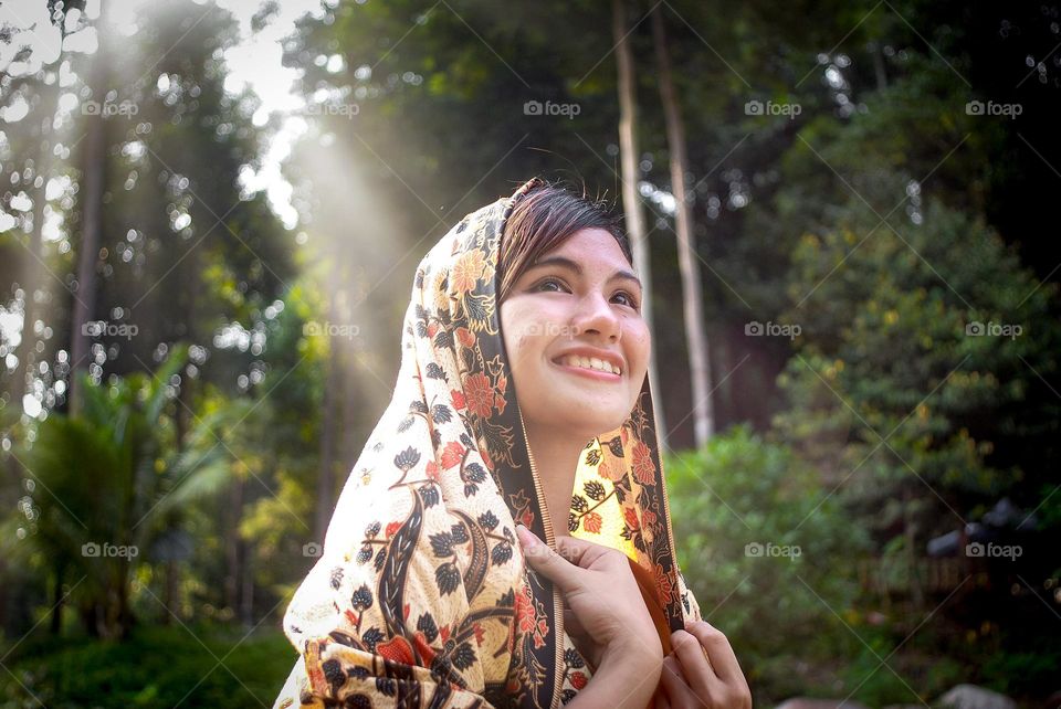 Girl with sarong' cloth on evening ray light at nature background