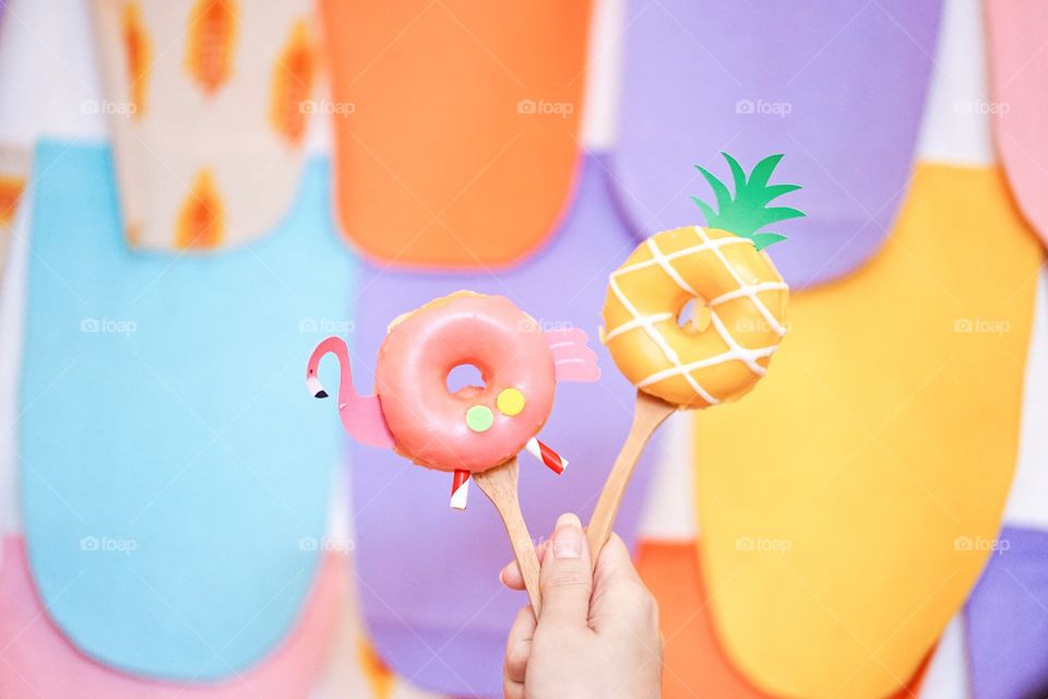 Cute donut. Cute flamingo and pineapple sugar glazed doughnuts served on a wooden table, soft focus. Summer theme. Fancy food concept for birthday or creative party.