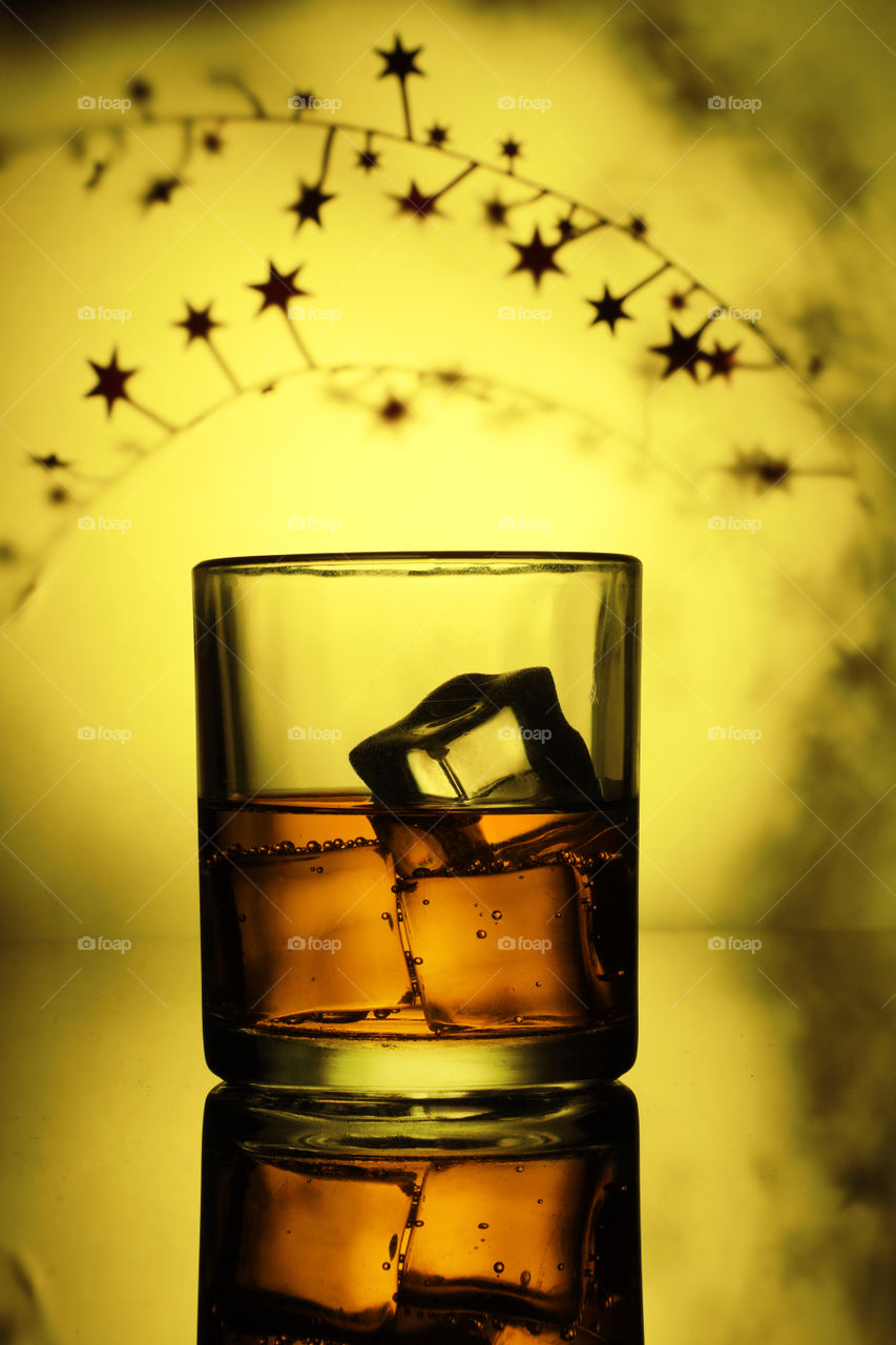 A whisky or tum drink with ice cubes