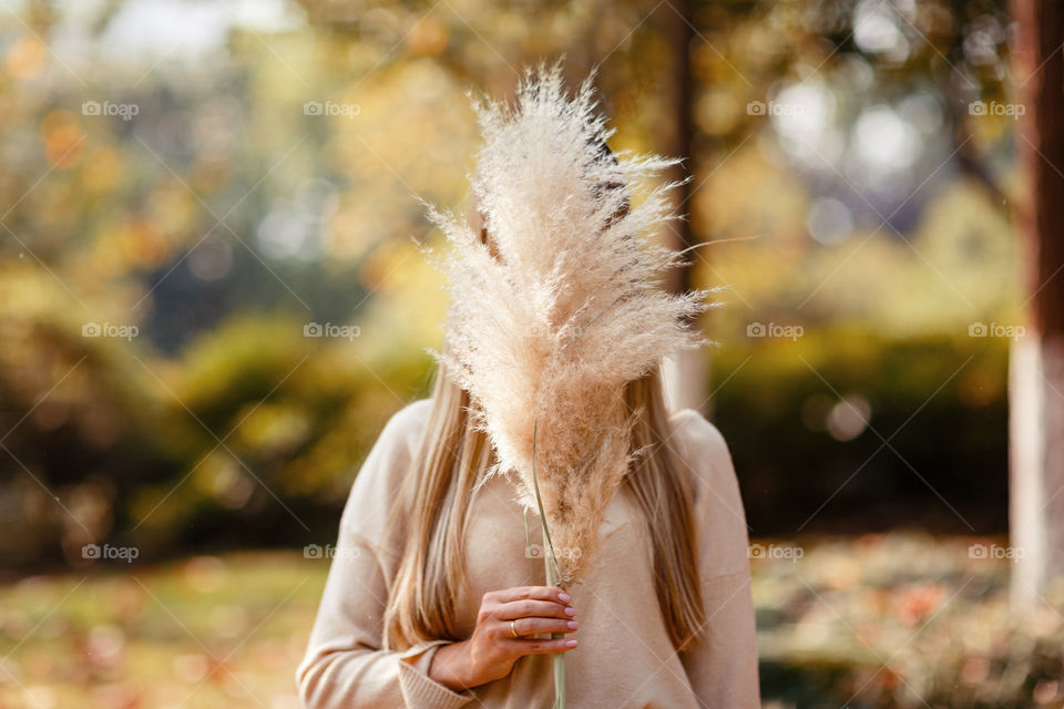 Woman holding hand dry flower outdoor 