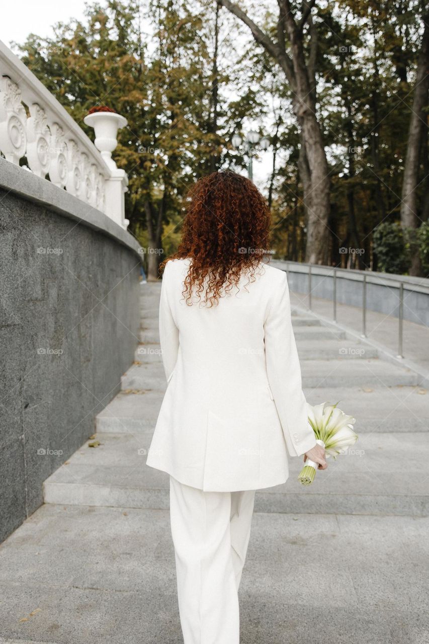 Bride with curls hair in white costume