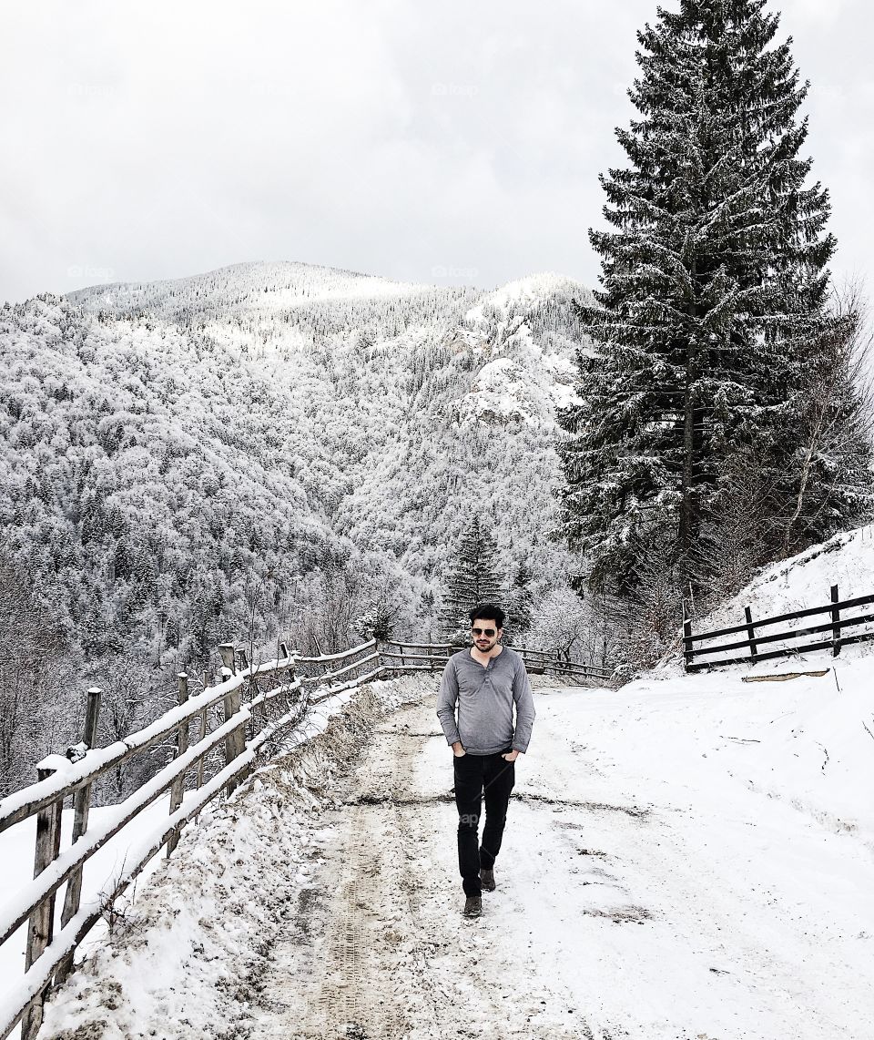 Young man walking on road during winter