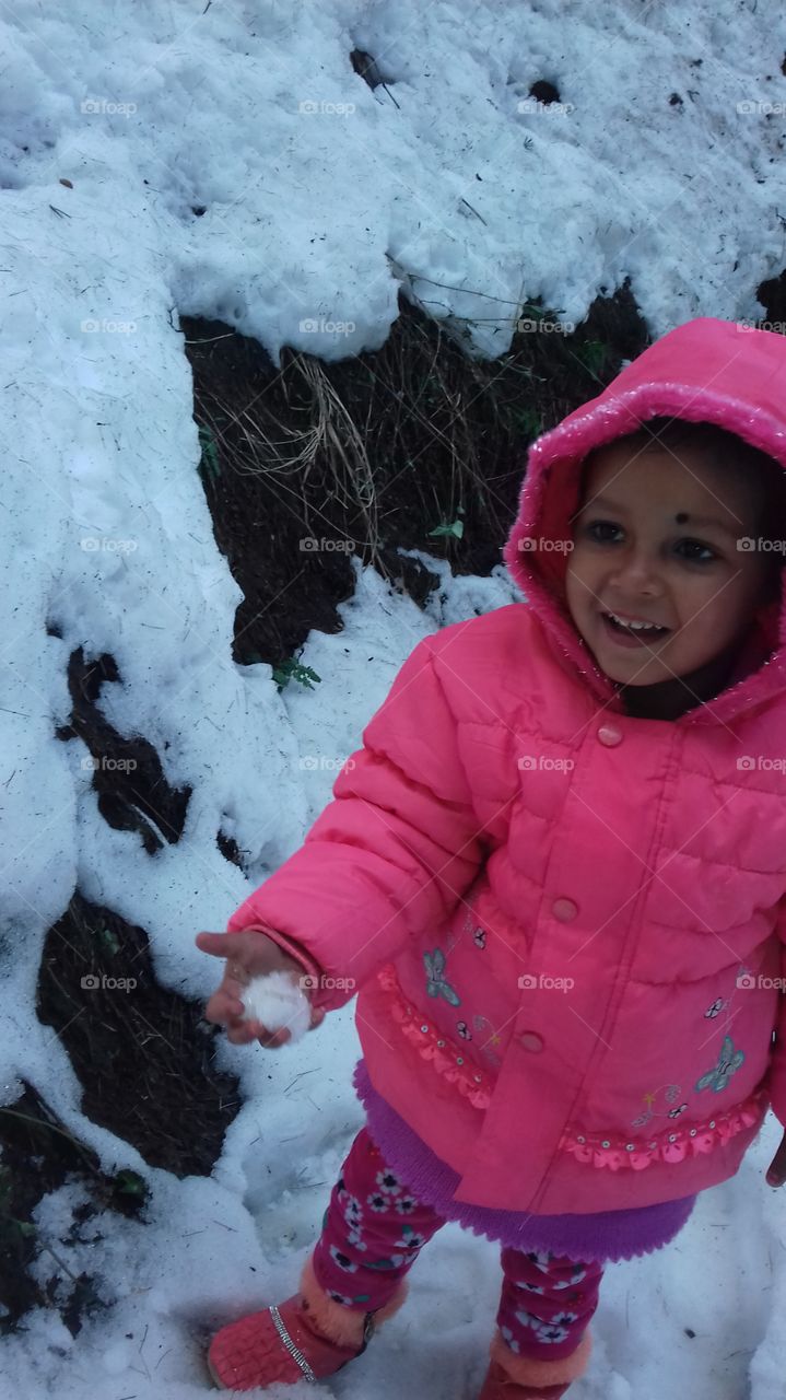Cute little girl standing on snow