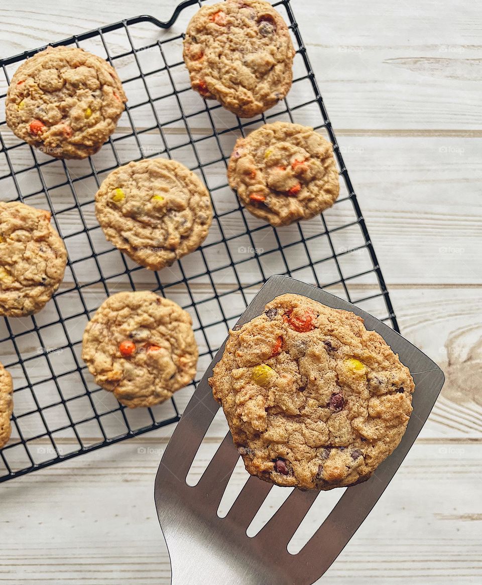 Placing homemade cookies onto a cooling rack, baking homemade cookies, baking cookies at home, food photography with a smartphone, cookie on a spatula, perspective of a baker, homemade deliciousness, Reese’s Pieces Chocolate Chip Cookies