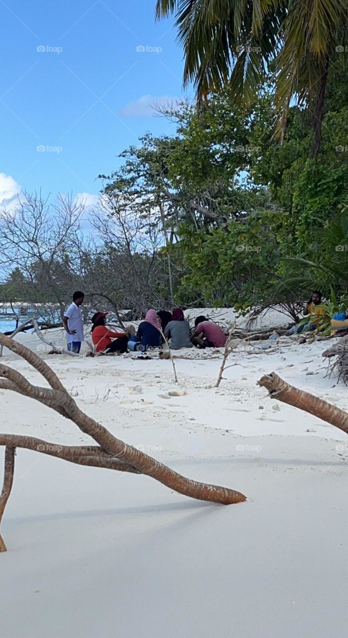 It’s a beautiful day in Maldives. Here a group of friends having fun in a white sandy beach.