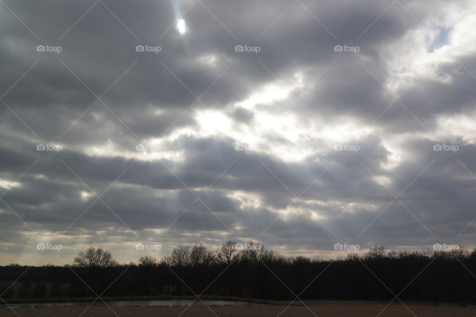 Sun rays shine through the clouds on a cool autumn day.