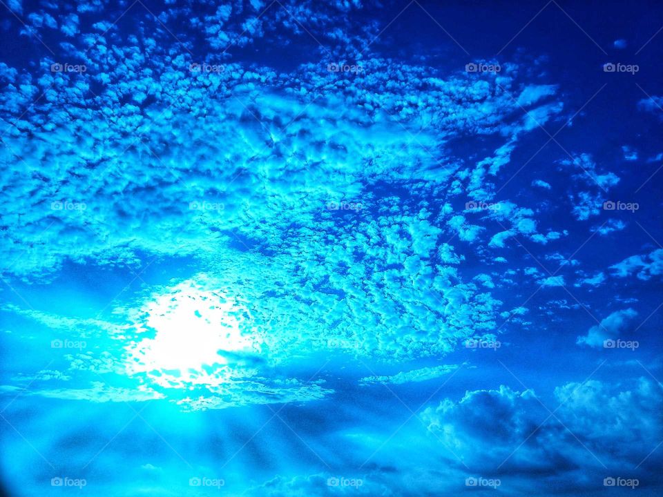 blue and cloudy sky with spreading sun spectrum or rays penetrating cloud. captured at afternoon, sunny day, and perfect scene, natural, beautiful moment,
