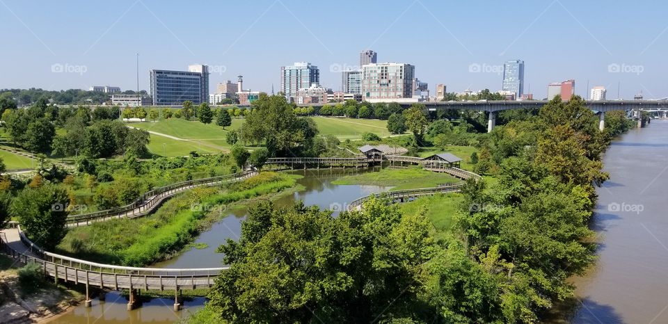A view of a city and park in Arkansas, taken from a bridge.