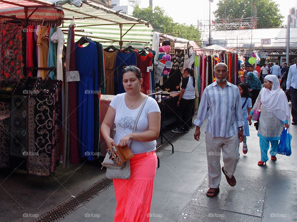 Crowds of people out walking, shopping, and eating, on European streets on a summer day. 