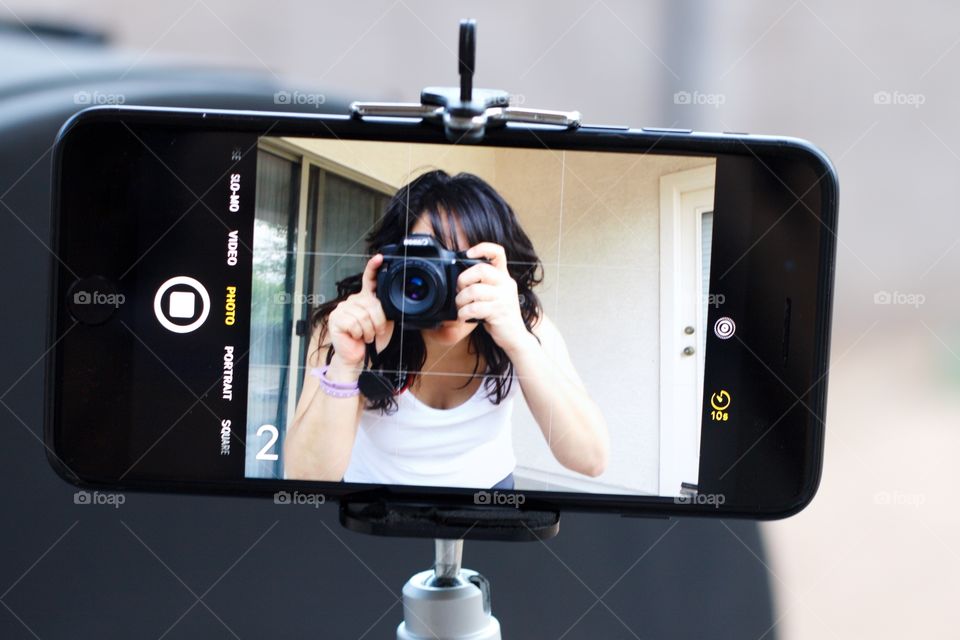 Woman taking a selfie on iPhone with Canon 70D