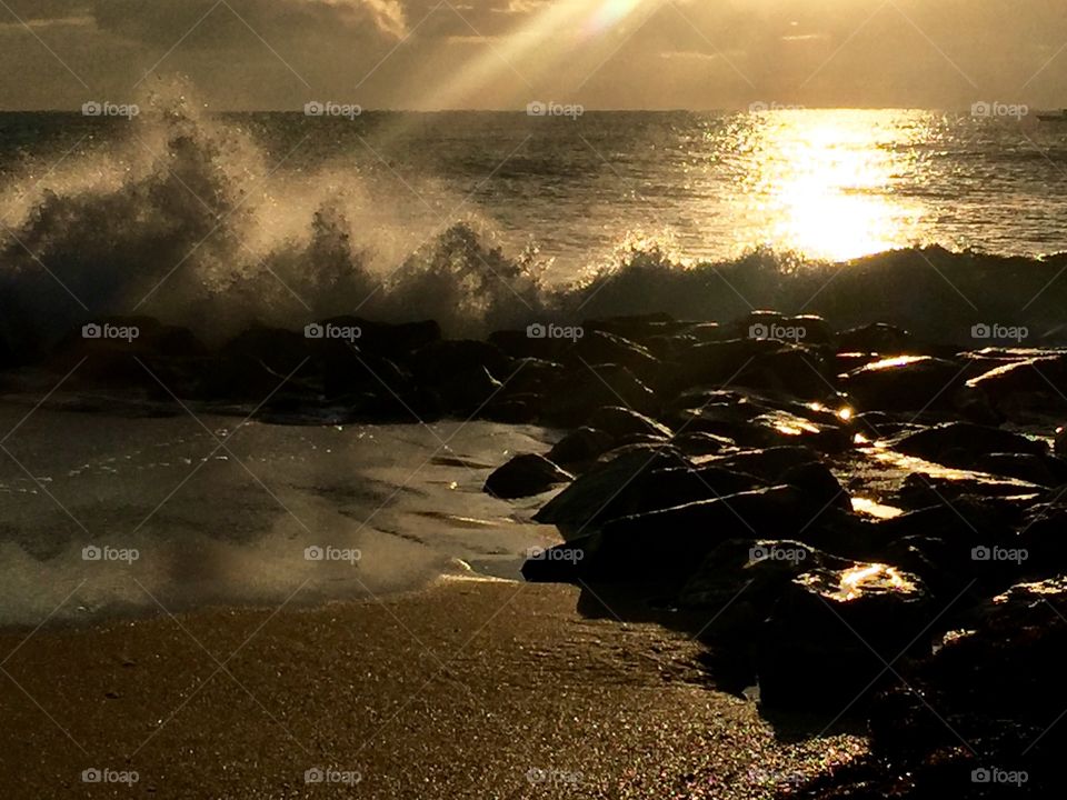 Sunrise at Boynton beach inlet as waves crashed against the rocks, Florida